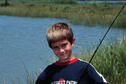 A young boy shows off his latest catch