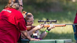Girl learning to shoot rifle